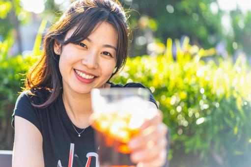 アイスコーヒーで乾杯する女性 アイスコーヒーで乾杯する女性の写真