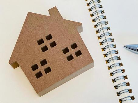 リングノートの上の茶色い家の模型 リングノートの上の茶色い家の模型 不動産投資,空き家,家の写真素材