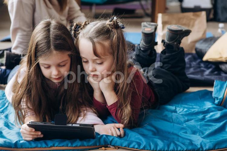 頬杖をついてタブレットを見る女の子たち 女の子,人物,貧困の写真素材