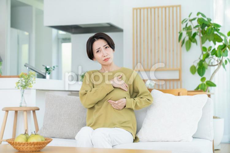 胸に違和感を感じるミドルの女性 乳癌,乳がん,違和感の写真素材