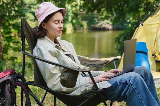黒椅子に座る女性キャンパー 女性,外国人,キャンプの写真素材