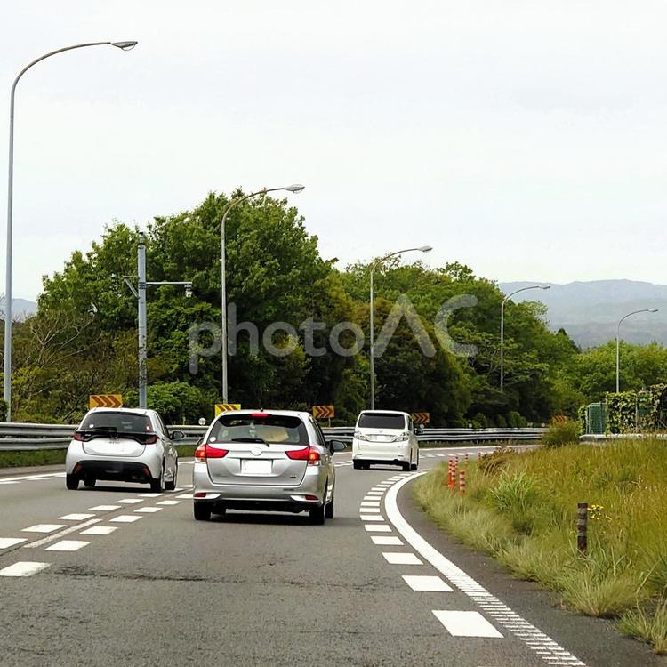 東名高速道路のくだり坂を走る カーブ,下り坂,坂道の写真素材