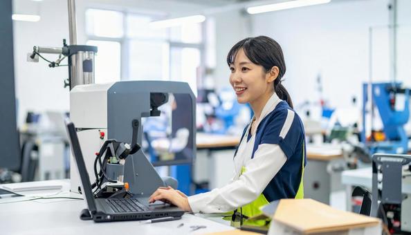 工場の三次元測定機を使う作業服の女性 工場の三次元測定機を使う作業服の女性の写真