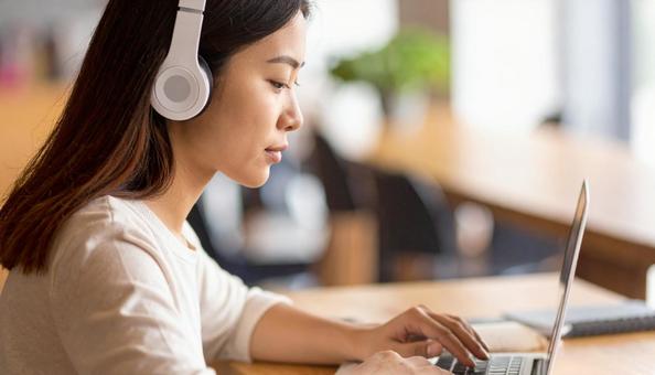 お気に入りの音楽を聴きながら勉強する女性の写真