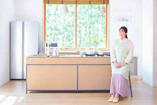 キッチンで笑うスカートの女性 キッチンで笑うスカートの女性 女性,笑う,笑顔の写真素材