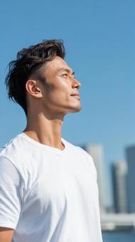 青空を見上げる白Tシャツの爽やか男性 青空を見上げる白Tシャツの爽やか男性の写真