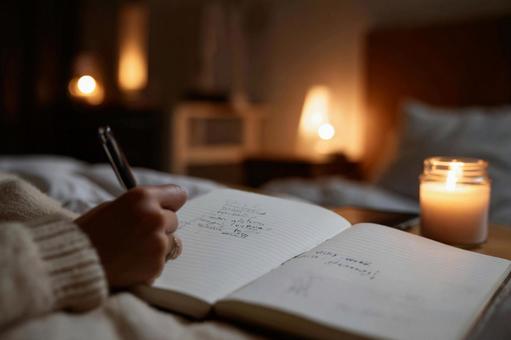 柔らかな光の中でジャーナルに書き込む女性 柔らかな光の中でジャーナルに書き込む女性の写真
