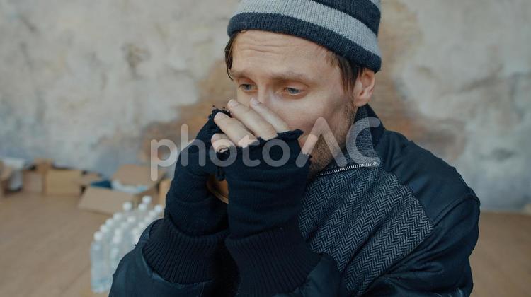 口元を隠して温める男性 男性,ニット帽,人物の写真素材
