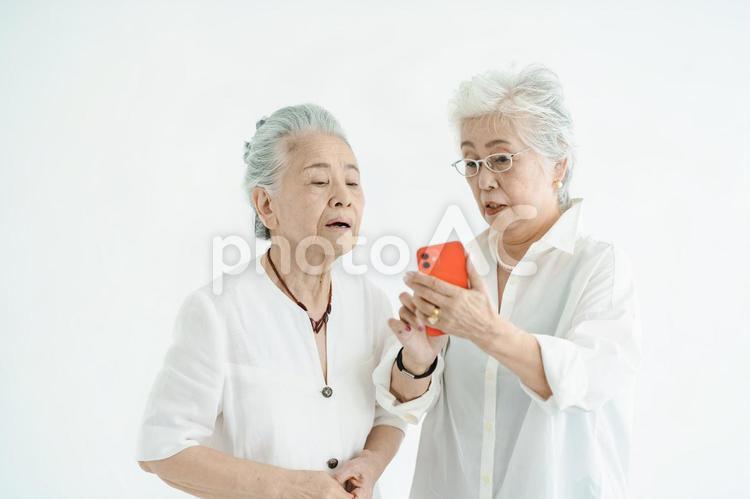 スマートフォンの画面を見るシニア女性たち  スマートフォン,シニア,おばあちゃんの写真素材