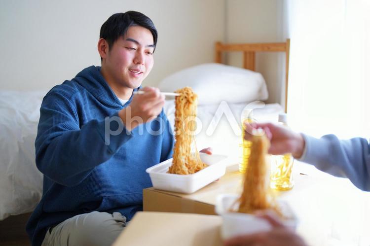 引っ越しの合間にカップ焼きそばを食べる2人の男性 引っ越し,一人暮らし,男性の写真素材