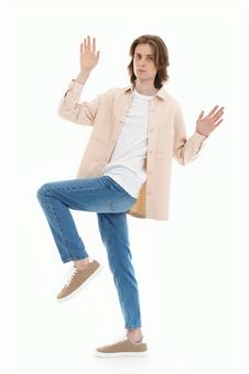 片足立ちでカメラ目線でポーズする男性 片足立ちでカメラ目線でポーズする男性の写真