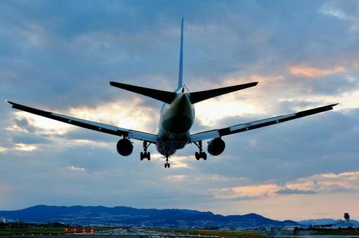 夕焼け空｜着陸する大型機 飛行機,着陸,夕焼けの写真素材