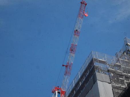 秋分過ぎの青空背景のタワークレーンの写真