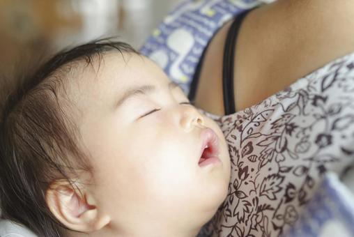 ママの背中で熟睡する赤ちゃんの寝顔 ママの背中で熟睡する赤ちゃんの寝顔の写真