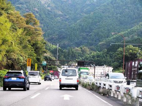 山の緑に囲まれて走る 国道,道路,自動車の写真素材