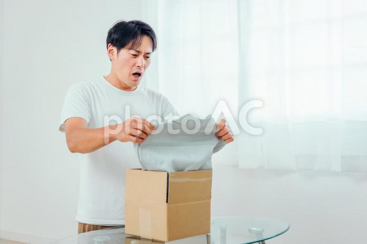 届いた商品に納得がいかない男性（不良品・返品） 不良品,返品,クーリングオフの写真素材