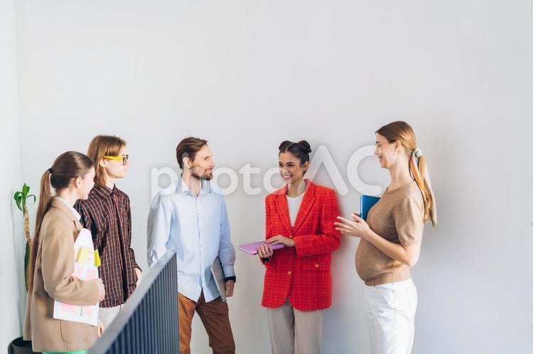 オフィスで立ち話をする5人の男女 ビジネス,ビジネスマン,ビジネスウーマンの写真素材