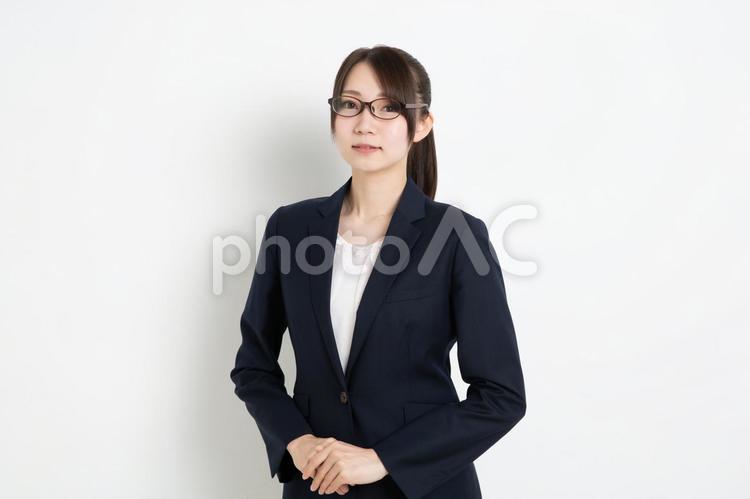 両手を前に添えて笑っているメガネのビジネスウーマン 女,女性,日本人の写真素材