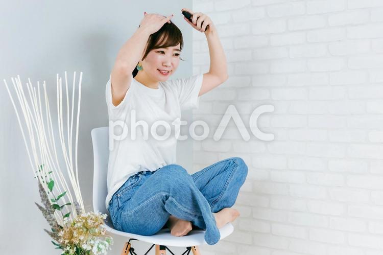 髪の毛にヘアケア用品をつける日本人女性 ヘアオイル,ヘアケア,スタイリング剤の写真素材