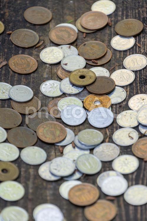 木のテーブルに散らばった日本の硬貨 硬貨,お金,円の写真素材