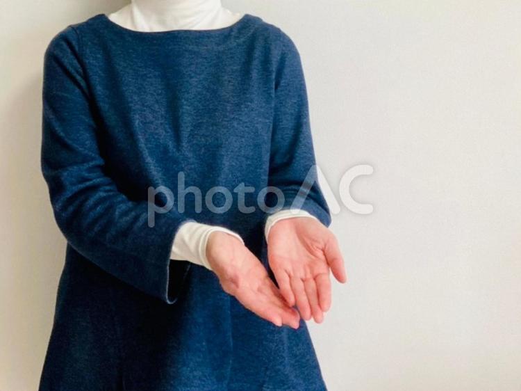 両手を斜め前に差し出す女性 両手,どうぞ,あげるの写真素材