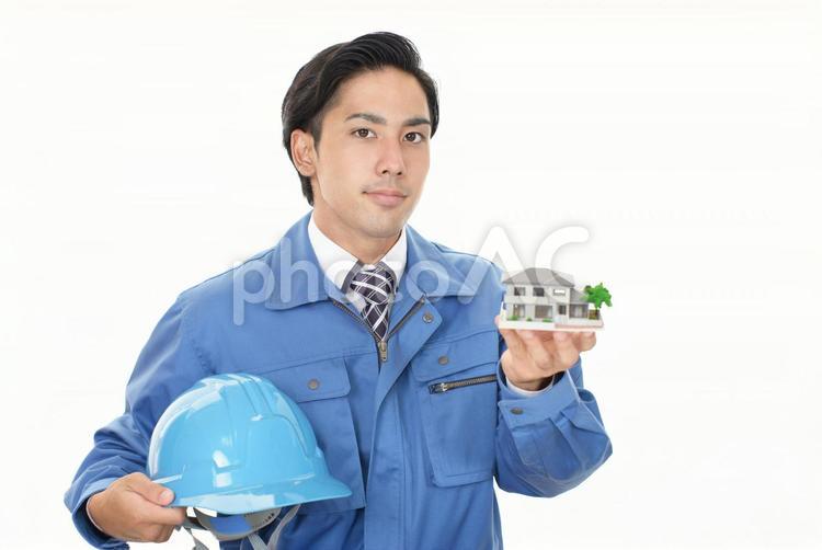 家の模型を持つ労働者 作業員,作業着,作業服の写真素材