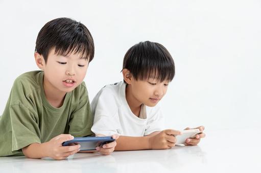 スマホに夢中になる子ども スマホに夢中になる子ども 男の子,スマホ,インターネットの写真素材