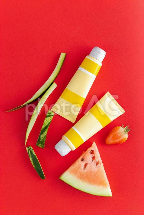 いちごとスイカと黄色いチューブ（赤背景） モックアップ,物撮り,化粧品の写真素材