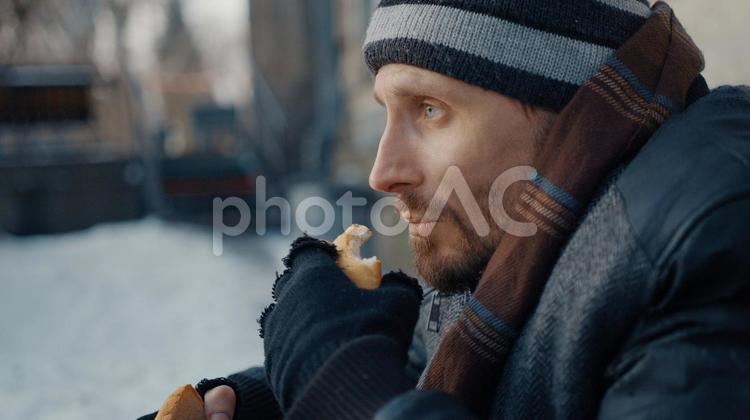 パンを食べる男性のホームレス 男性,ニット帽,人物の写真素材