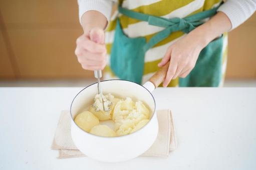 鍋に入ったジャガイモを潰している人の手 鍋に入ったジャガイモを潰している人の手 ジャガイモ,潰す,マッシャーの写真素材