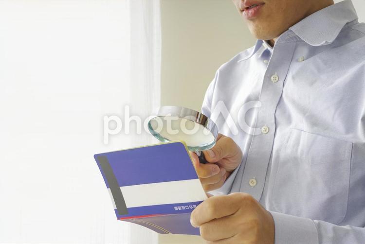貯金通帳を見つめる中年男性 通帳,給料,給与の写真素材