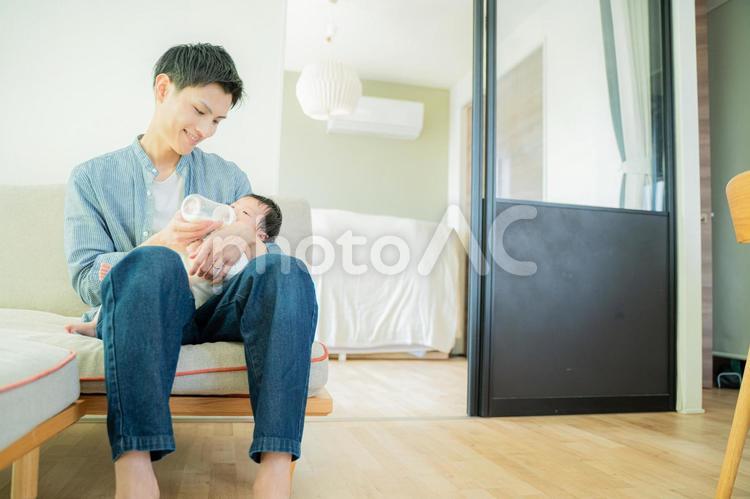 ソファーに座って赤ちゃんに微笑むパパ パパ,父親,赤ちゃんの写真素材
