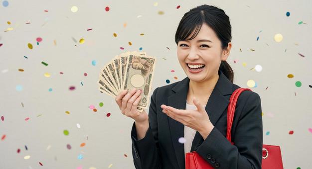 お札を手にして喜ぶ女性 お札を手にして喜ぶ女性の写真