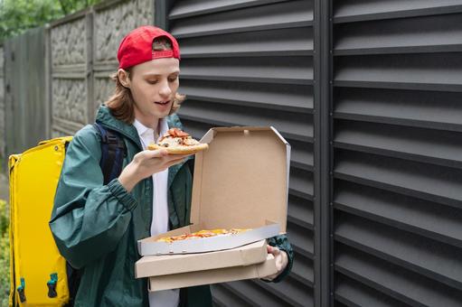 ピザ箱からピザを取り出すフードデリバリーの男性 配達,デリバリー,配送の写真素材