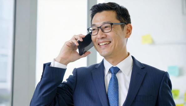 電話するサラリーマン 電話するサラリーマンの写真