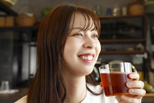 笑顔でアイスティーを飲む女性 笑顔でアイスティーを飲む女性 女性,若い,笑顔の写真素材