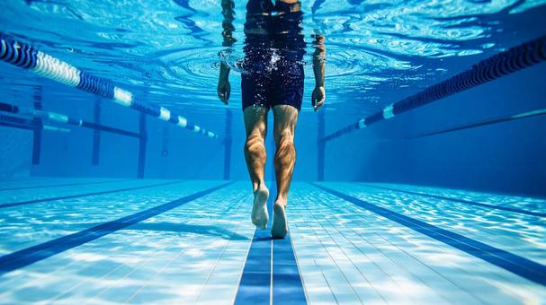 腰あたりまで水に浸かって歩く男性 腰あたりまで水に浸かって歩く男性の写真