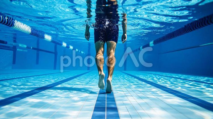 腰あたりまで水に浸かって歩く男性 男性,プール,水中の写真素材