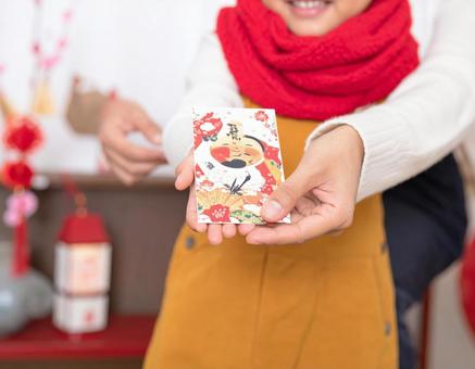 正月にポチ袋でお年玉をもらって喜ぶ子供 正月にポチ袋でお年玉をもらって喜ぶ子供の写真