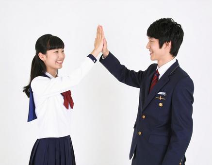 ハイタッチする高校生の男女生徒の写真