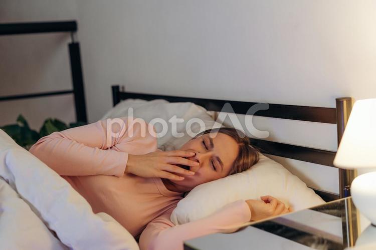 手を添えてあくびする女性 女性,ロングヘア,寝るの写真素材