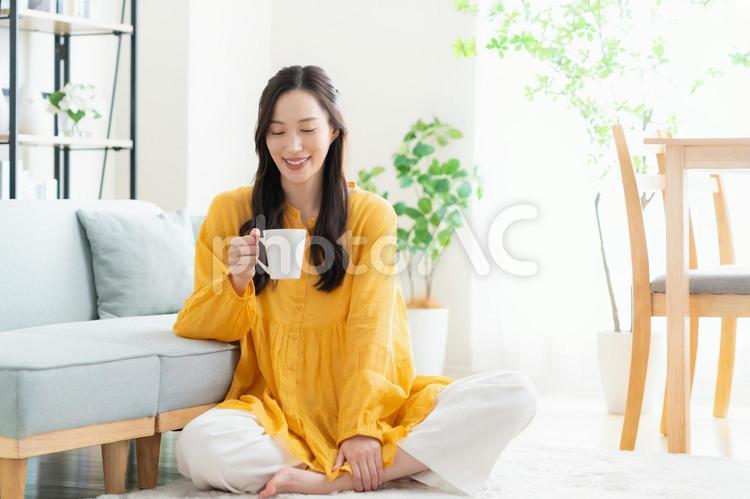 リビングでくつろぐ若い女性 女性,コーヒー,コーヒーブレイクの写真素材