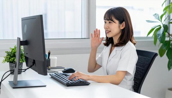 パソコンに向かって話す女性 パソコンに向かって話す女性の写真