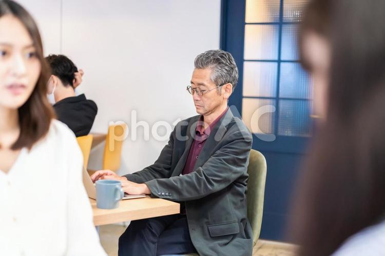 カフェで仕事をする中年男性 カフェ,テレワーク,リモートワークの写真素材