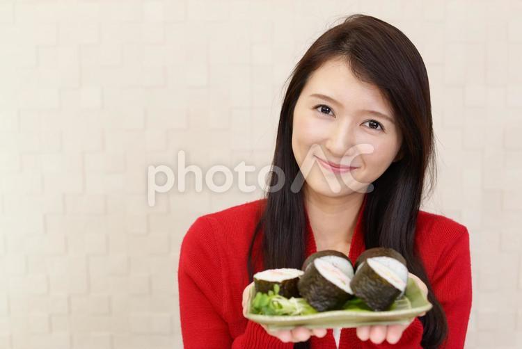 お寿司を持つ笑顔の女性 女性,女,お寿司の写真素材