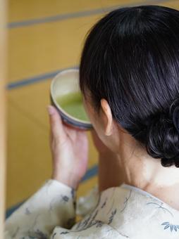お抹茶をいただく女性の後ろ姿 お抹茶をいただく女性の後ろ姿の写真