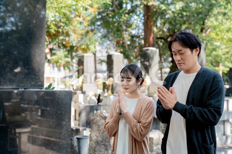 お墓参りする男女（合掌） お墓参り,墓参り,お墓の写真素材