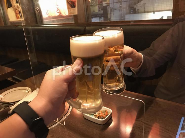 コロナ禍で、アクリル板越しに乾杯する 乾杯,居酒屋,飲酒の写真素材