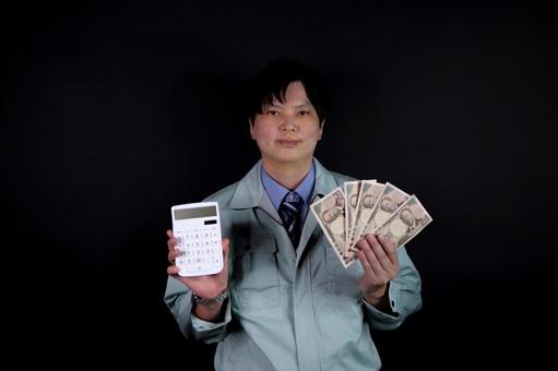 電卓とお金を持つ作業服男性 電卓とお金を持つ作業服男性 男性,作業服,電卓の写真素材