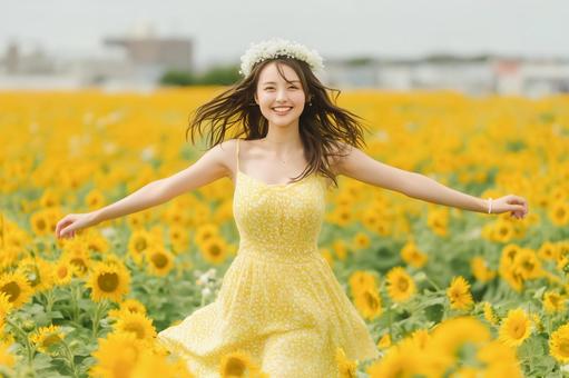 ひまわり畑で花冠をつけた笑顔の女性 ひまわり畑で花冠をつけた笑顔の女性の写真